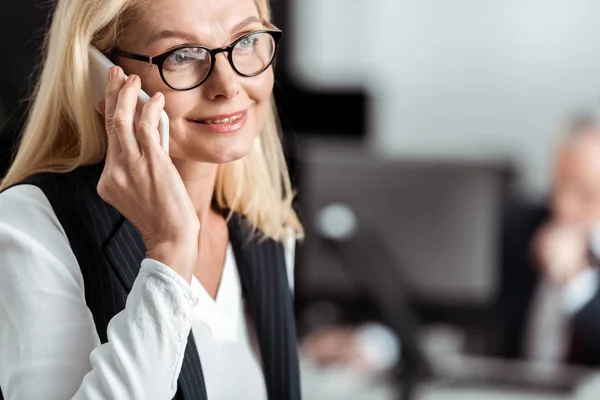 Primer plano de la mujer de negocios feliz en gafas hablando en el teléfono inteligente - foto de stock