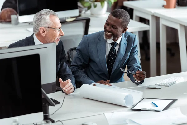 Overhead view of happy multicultural businessmen smiling in office — Stock Photo