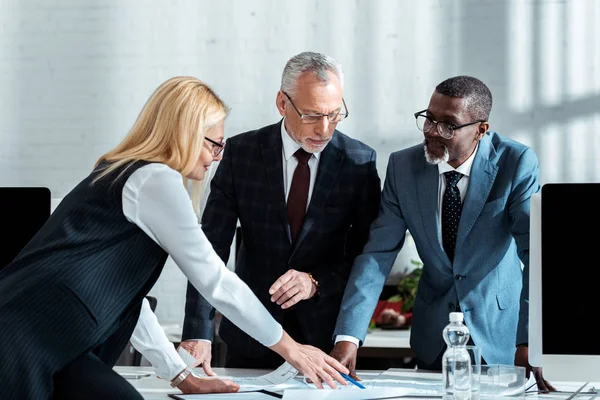 Vista recortada del hombre de negocios afroamericano y la mujer de negocios estrechando la mano en el cargo - foto de stock