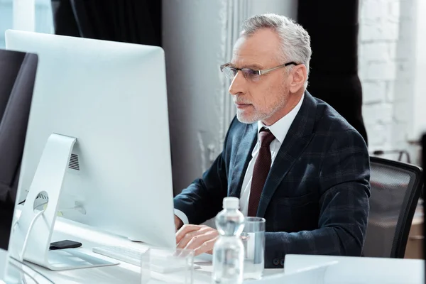 Enfoque selectivo de hombre de negocios en gafas de trabajo en la oficina moderna - foto de stock