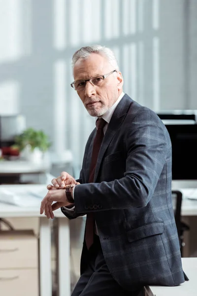 Красивий бізнесмен в офіційному носити зворушливий годинник в сучасному офісі — стокове фото