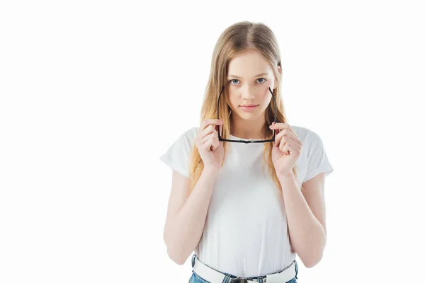 Allegra ragazza adolescente tenendo gli occhiali e guardando la fotocamera isolata su bianco — Foto stock