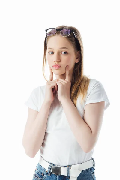 Adolescente en gafas tocando la cara y mueca aislado en blanco - foto de stock