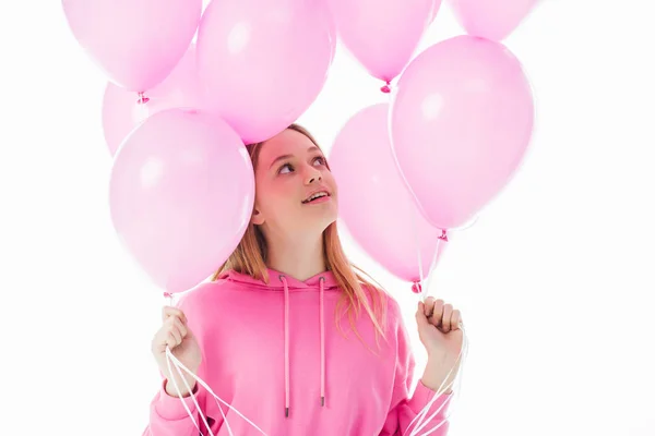 Happy teenage girl looking at pink balloons isolated on white — Stock Photo