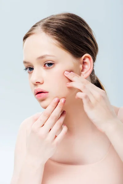 Upset teenage girl having acne on face isolated on grey — Stock Photo