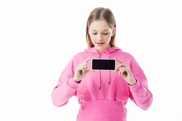 Teenage girl in pink hoodie holding smartphone with blank screen isolated on white — Stock Photo