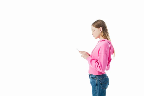 Side view of teenage girl in pink hoodie using smartphone isolated on white — Stock Photo