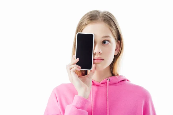 Adolescente en sudadera con capucha rosa con teléfono inteligente con pantalla en blanco frente a la cara aislada en blanco - foto de stock