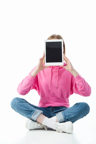 Teenage girl in lotus pose holding digital tablet with blank screen isolated on white — Stock Photo