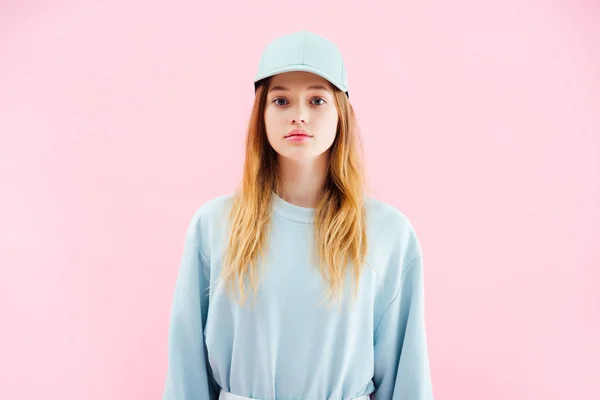 Traurige hübsche Teenager-Mädchen mit Mütze, die in die Kamera schaut, isoliert auf rosa — Stockfoto