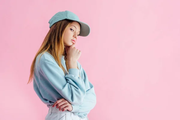 Pensativo triste bonita adolescente en gorra aislado en rosa - foto de stock