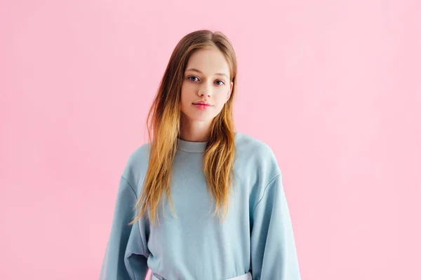 Bela sorridente adolescente olhando para a câmera isolada em rosa — Fotografia de Stock