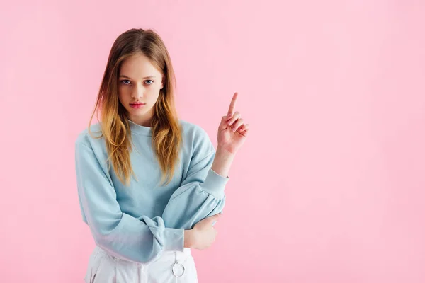 Sad teenage girl pointing with finger isolated on pink — Stock Photo