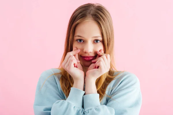 Bastante adolescente chica tocando mejillas aislado en rosa - foto de stock