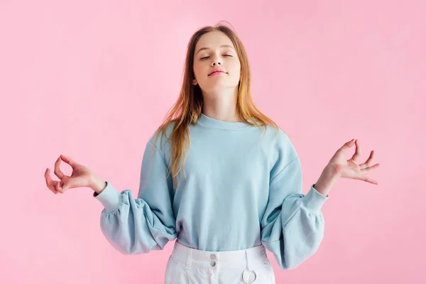 Bella ragazza adolescente con gli occhi chiusi meditando isolato su rosa — Foto stock