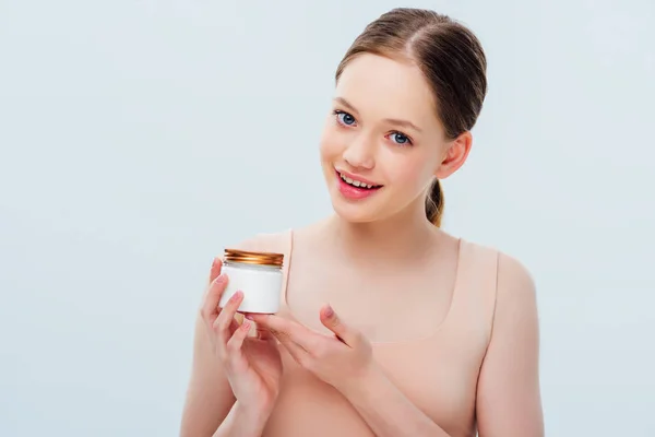 Happy smiling teenage girl holding cosmetic cream in hands isolated on grey — Stock Photo