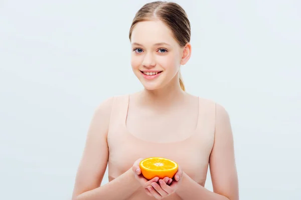 Teenage girl with smile holding ripe orange half isolated on grey — Stock Photo