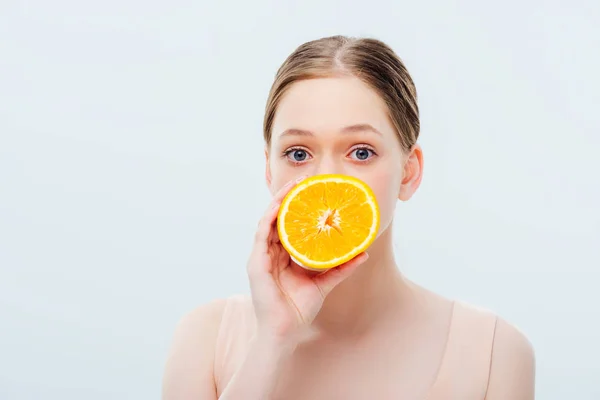 Teenage girl with obscure face holding ripe orange half isolated on grey — Stock Photo