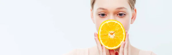 Adolescente con viso oscuro tenendo matura metà arancione isolato su bianco, colpo panoramico — Foto stock