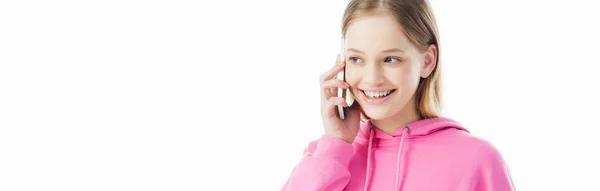 Plano panorámico de la adolescente feliz en sudadera con capucha rosa hablando en el teléfono inteligente aislado en blanco - foto de stock