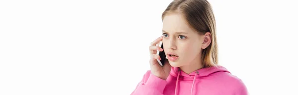 Plano panorámico de adolescente disgustada en sudadera con capucha rosa hablando en teléfono inteligente aislado en blanco - foto de stock