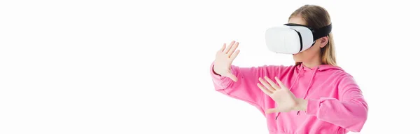 Panoramic shot of teenage girl in pink hoodie wearing vr headset and gesturing isolated on white — Stock Photo