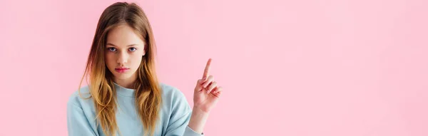 Plano panorámico de triste adolescente señalando con el dedo aislado en rosa - foto de stock