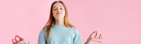 Panoramic shot of pretty teenage girl with closed eyes meditating isolated on pink — Stock Photo