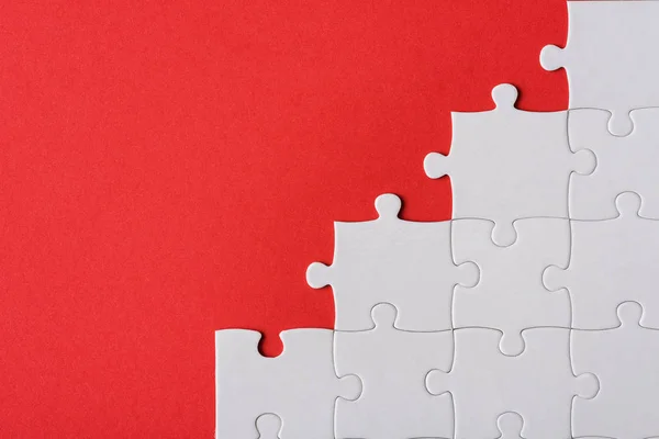 Vue de dessus des pièces de puzzle blanc connecté isolé sur rouge — Photo de stock