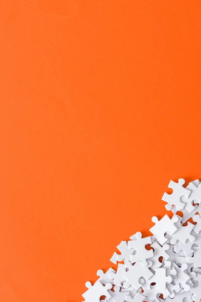 Top view of unfinished puzzle pieces isolated on orange with copy space — Stock Photo