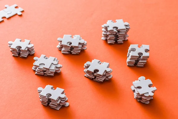 Selective focus of stacked white puzzle pieces on orange — Stock Photo