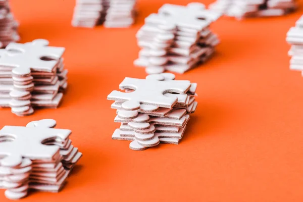 Foco seletivo de peças de quebra-cabeça branco pilhas em laranja — Fotografia de Stock