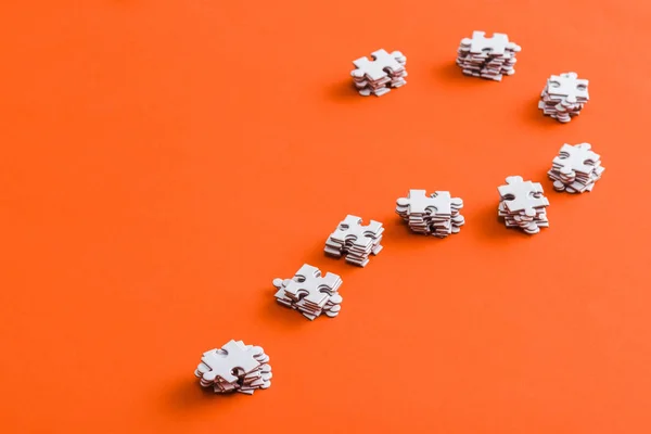 Question mark shape with white jigsaw puzzle pieces on orange — Stock Photo