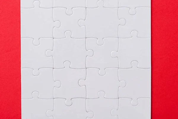 Top view of set with white jigsaw puzzle pieces isolated on red — Stock Photo