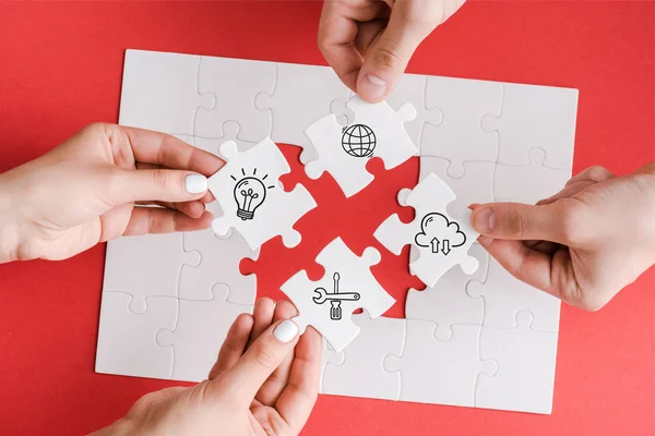 Top view of man and woman holding white puzzle pieces with illustration on white — Stock Photo