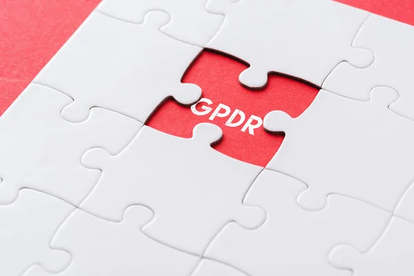 Top view of white incomplete jigsaw puzzle pieces with gpdr lettering on red — Stock Photo