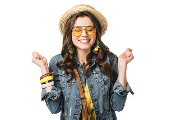 Excitada chica boho en boater y gafas de sol sosteniendo puños con los ojos cerrados aislados en blanco - foto de stock