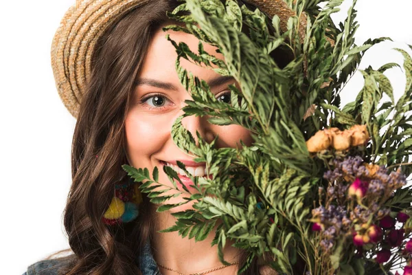 Sonriente chica boho feliz en sombrero de paja sosteniendo flores aisladas en blanco - foto de stock