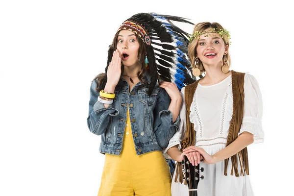 Two amazed bisexual hippie girls in indian headdress and wreath isolated on white — Stock Photo