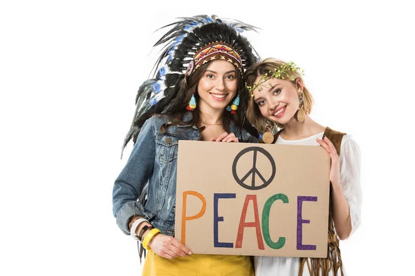 Zwei bisexuelle Hippie-Mädchen in indischer Kopfbedeckung und Kranz mit Plakat mit Inschrift isoliert auf weiß — Stockfoto