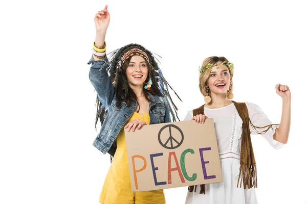 Two bisexual hippie girls in indian headdress and wreath holding placard with inscription isolated on white — Stock Photo