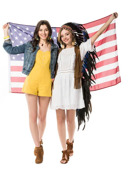 Vista completa de dos chicas hippies bisexuales sonrientes sosteniendo bandera americana aislada en blanco - foto de stock