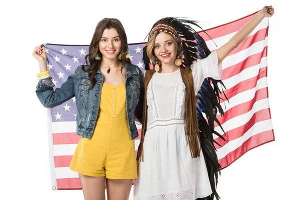 Dos niñas hippies bisexuales sonrientes sosteniendo bandera americana aislada en blanco - foto de stock