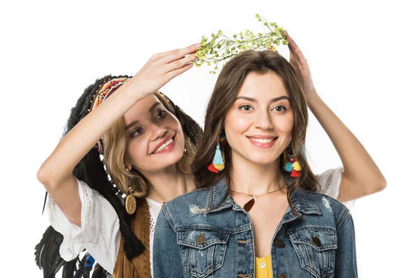 Sorridente menina em indiana cobertura para a cabeça colocando coroa de flores em amigo isolado no branco — Fotografia de Stock