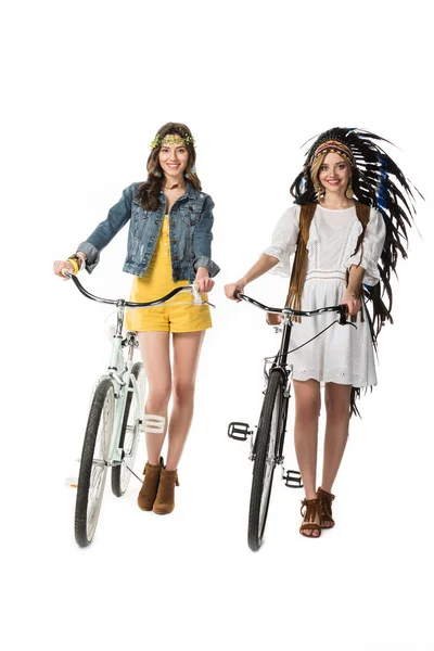 Vue pleine longueur de deux filles boho avec des vélos isolés sur blanc — Photo de stock