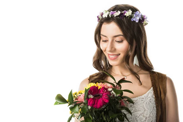 Smiling hippie woman in wreath holding flowers isolated on white — Stock Photo