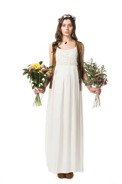 Vista a tutta lunghezza della donna hippie incinta in ghirlanda che tiene fiori isolati su bianco — Foto stock