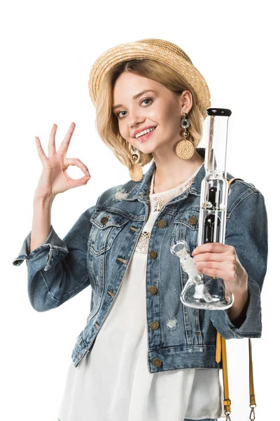 Chica hippie con estilo sosteniendo la pipa y mostrando signo bien aislado en blanco - foto de stock