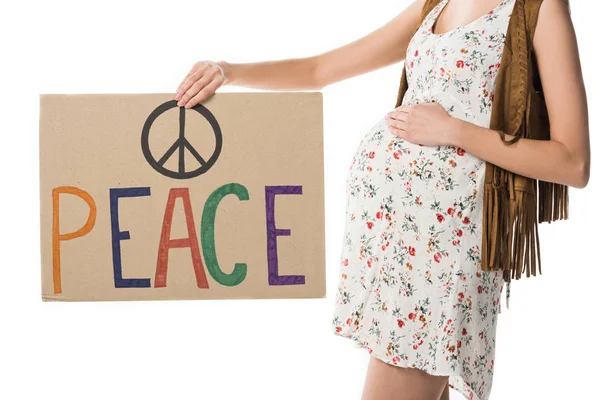 Vista recortada de la mujer hippie embarazada sosteniendo pancarta con inscripción aislada en blanco - foto de stock