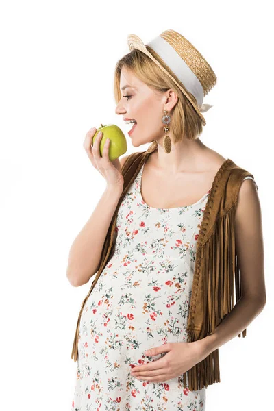 Гарне хіпі вагітна жінка їсть зелене яблуко ізольовано на білому — стокове фото